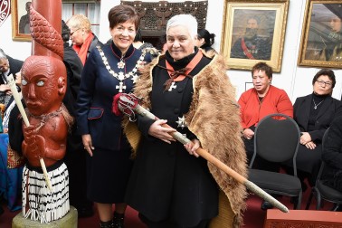 Image of Dame Patsy with Dame Tariana, who is Wearing a cloak and holding the sword of Te Keepa, a link to Queen Victoria