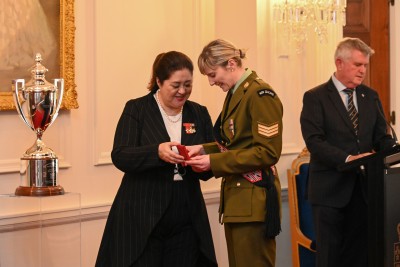 Dame Cindy inspecting the medal with recipient Corporal Rebekah Salt